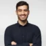 Smiling man in a dark shirt with crossed arms