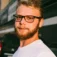 Man with glasses and a beard outdoors